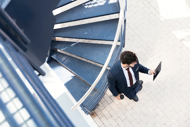 Free photo top view lawyer standing with tablet near stairs