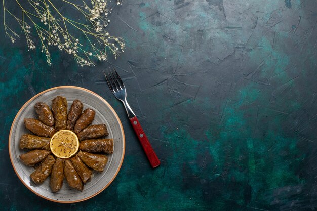 Top view leaf dolma delicious eastern meat meal rolled inside green leaves on the blue desk meat food dinner dish vegetables health