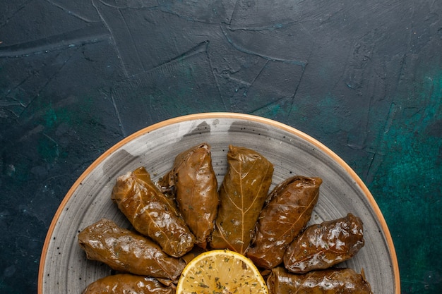 Top view leaf dolma delicious eastern meat meal rolled inside green leaves on the dark-blue desk meat meal food dinner dish vegetable health calories