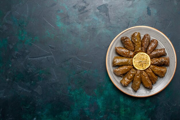 Top view leaf dolma delicious eastern meat meal rolled inside green leaves on dark-blue desk meat meal food dinner vegetable health calorie dish