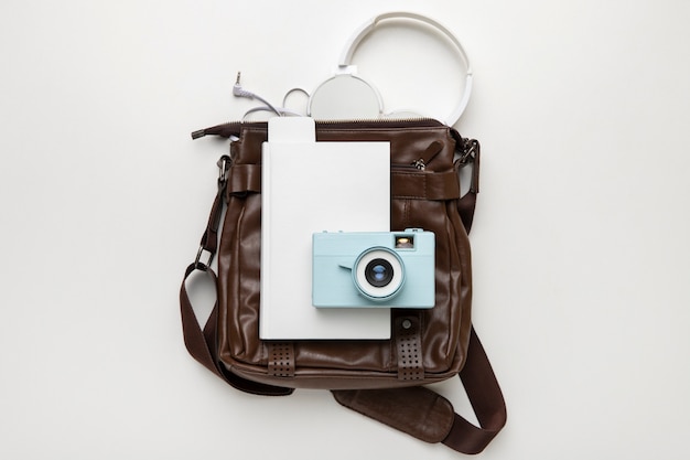 Top view of leather bag for travel with camera and notebook