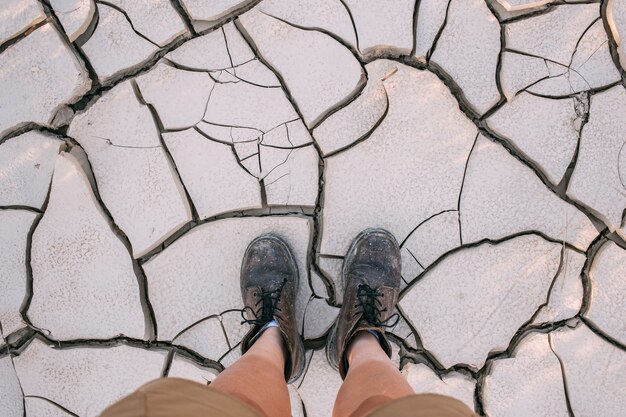 Top view on leather boots on cracked dry earth