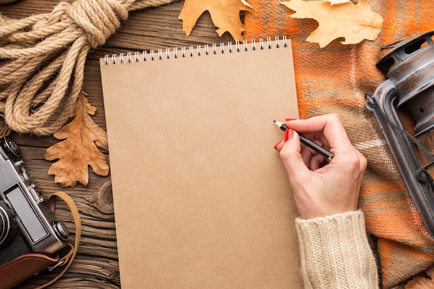 Free photo top view of leaves with notebook and camera