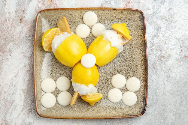 Top view lemon cocktails with white candies on white table fruit drink cocktail juice