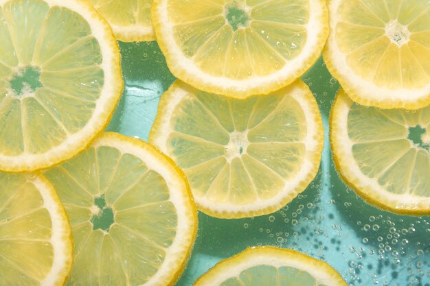 Вид сверху ломтики лимона и газированная вода