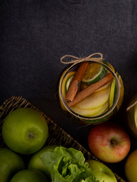 Top view lemon tea with lime cinnamon and apples with copy space