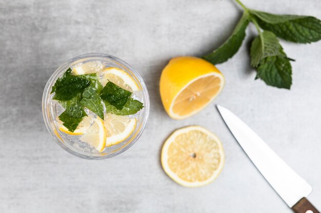 Top view of lemonade and mint leaves on wooden background