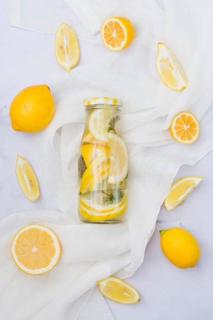 Free photo top view lemonade surrounded by lemons