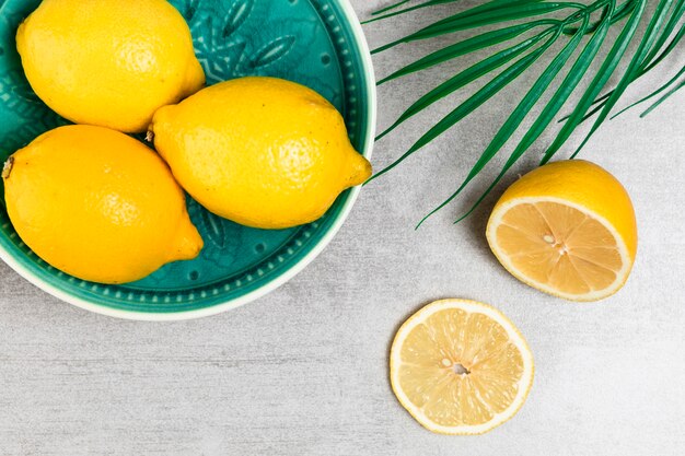 Top view of lemons in bowl on wooden background