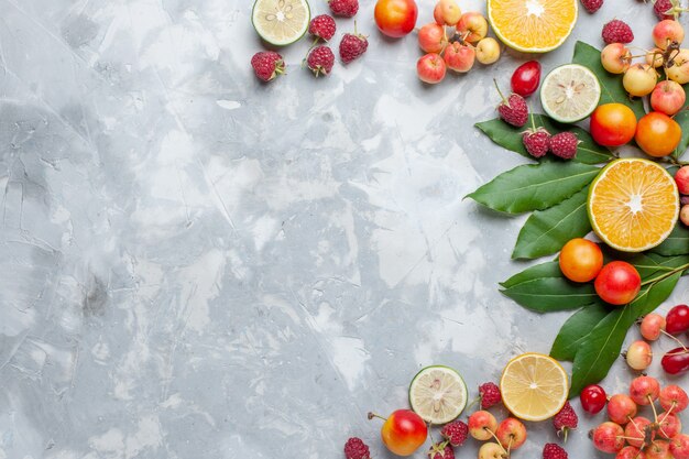 Top view lemons and cherries fresh fruits on light desk fruit fresh mellow ripe