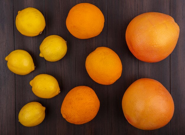 Вид сверху лимоны с апельсинами на деревянных фоне
