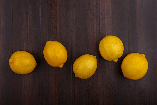 Top view lemons on wooden background