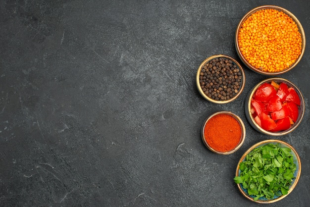 Top view of lentil bowls of lentil herbs tomatoes spices