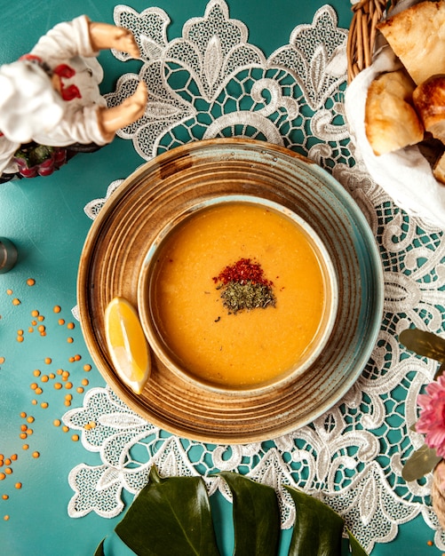 Top view of lentil merci soup in a bowl with a slice of lemon