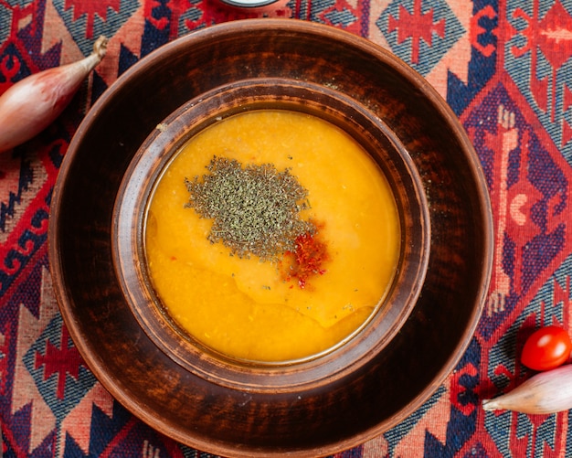 Вид сверху суп из чечевицы подается в деревянной миске в традиционной обстановке