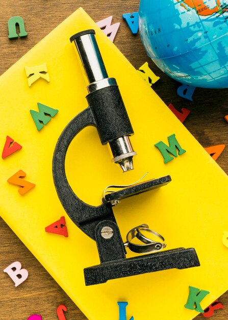 Top view of letters with microscope and globe