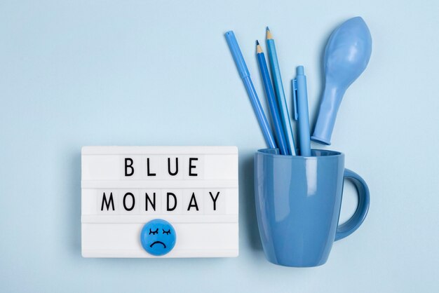 Top view of light box with mug and balloon for blue monday