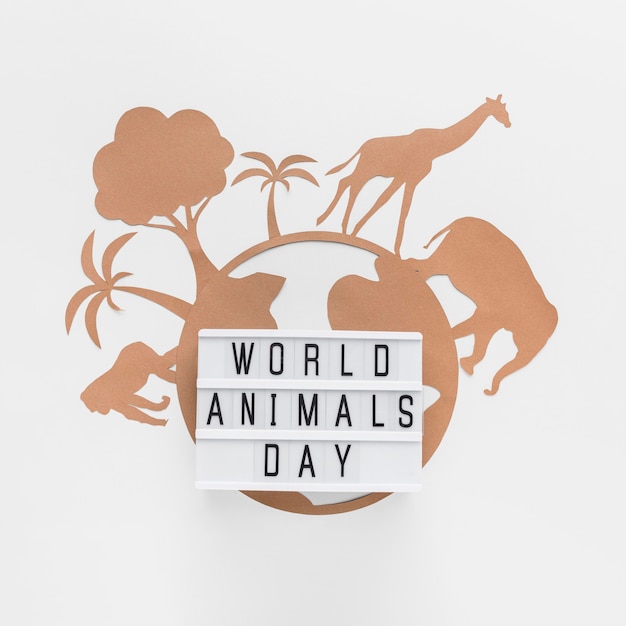 Free photo top view of light box with paper planet and animals for animal day