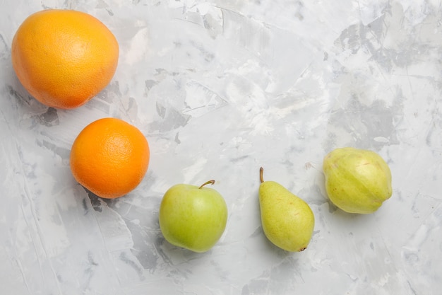 Вид сверху выложены свежими фруктами, грушами и мандаринами на белом фоне