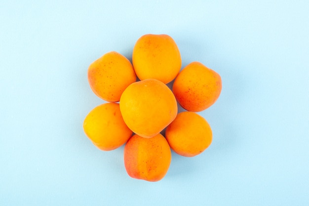 A top view lined orange peaches fresh mellow ripe isolated on the iced-blue background fruit vitamine juice