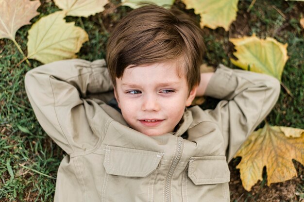 Вид сверху маленький мальчик, оставаясь на траве