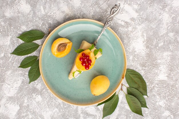 Top view little cake slice with apricots inside plate on the light background cake biscuit sugar sweet bake dough