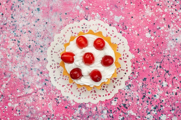 Foto gratuita vista dall'alto piccola torta con crema e frutta fresca sul colore del tè superficie colorata