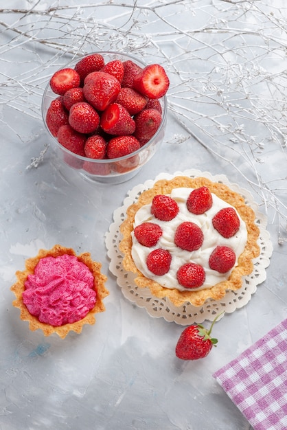 Top view of little cake with cream and fresh red strawberries pink cream cake on white desk, cake fruit berry biscuit cream