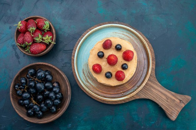 Top view little cake with fresh strawberries on dark blue surface