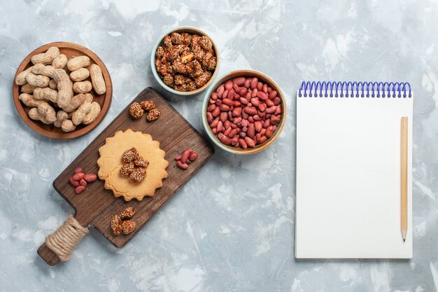 Top view of little cake with pistachios and nuts on light white surface