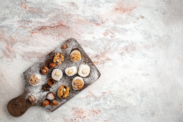 Free photo top view little cakes with walnuts and hazelnuts on white surface