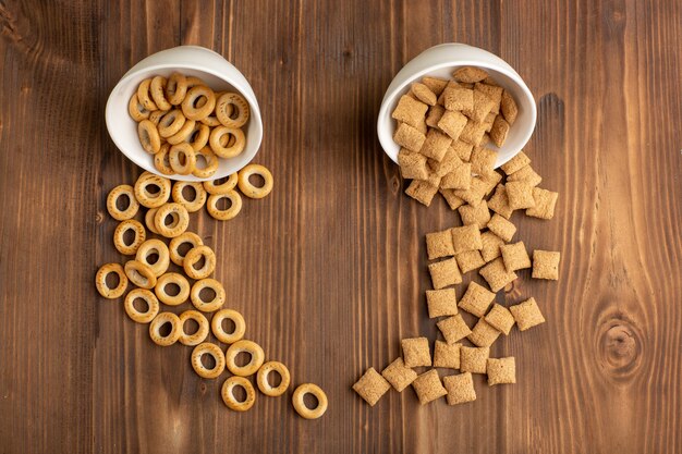 Top view little cookies and crackers on brown wooden desk