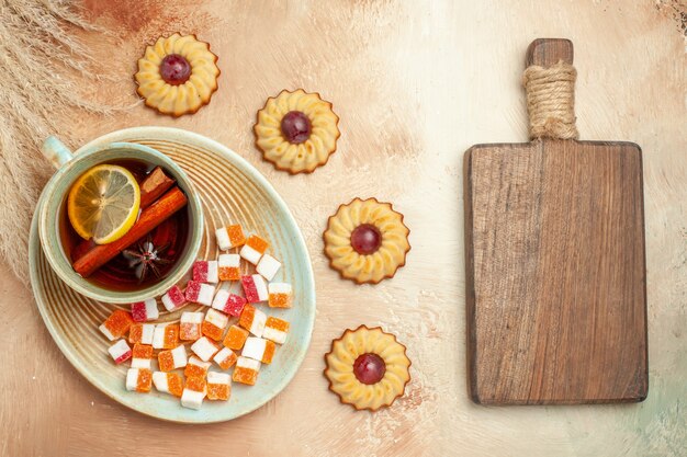 Top view little cookies with cup of tea on brown table, biscuit sweet cake dessert