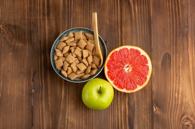 top view little cookies with grapefruit and apple on the brown wooden desk