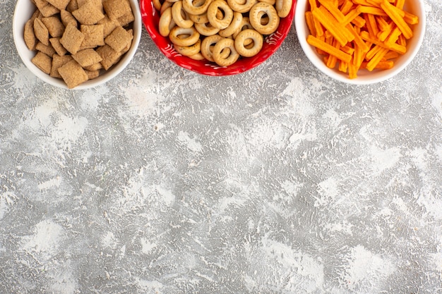 Foto gratuita vista dall'alto piccoli cracker con biscotti e fette biscottate sulla superficie bianca