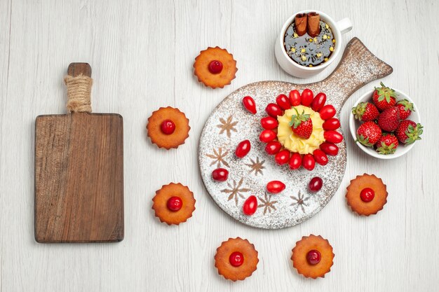 Top view little cream cake with fruits and cakes on a white desk