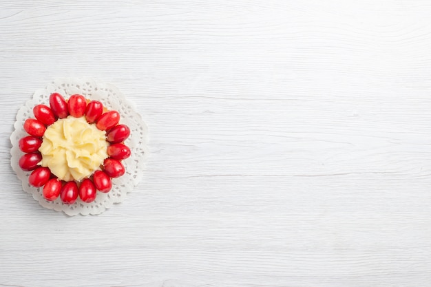 Top view little creamy cake with dogwoods on white desk