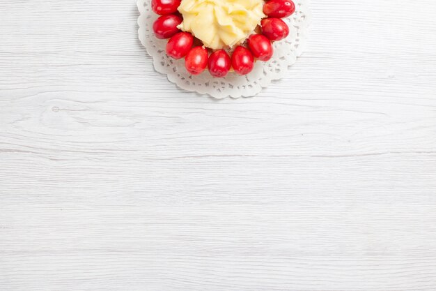 Top view little creamy cake with dogwoods on white desk