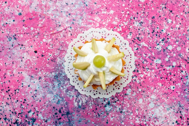 Top view little creamy cake with sliced fruits on the colored background cake sweet sugar bake color photo