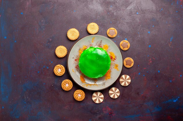 Top view little delicious cake with different cookies on the dark surface