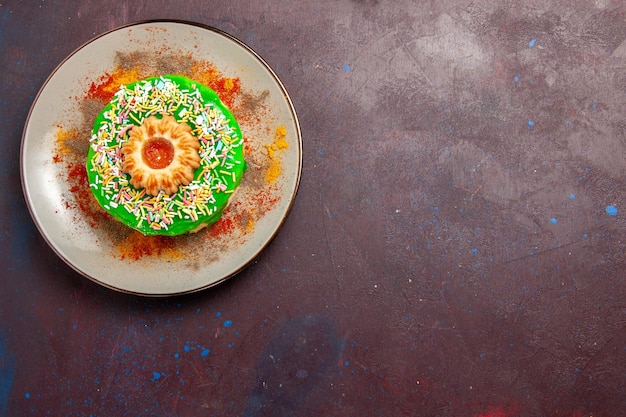 Foto gratuita vista dall'alto piccola deliziosa torta con crema verde sulla scrivania scura