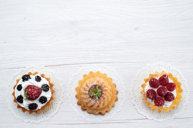 밝은 배경 케이크 비스킷 베리 과일 달콤한 설탕에 크림과 딸기와 상위 뷰 작은 맛있는 케이크
