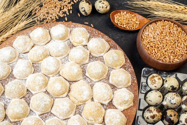 Top view little dough pieces with flour on the dark background color pie cake hotcake dough dumplings bun meat