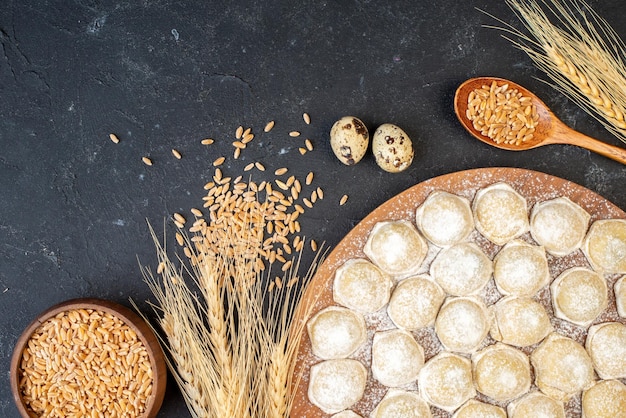 Top view little dough pieces with flour on dark background color pie cake hotcake dough dumplings buns meat