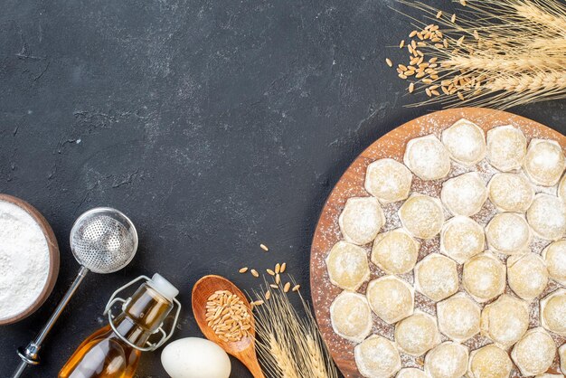 Top view little dough pieces with flour on a dark background dumpling color cake dough bun meat hotcake pie