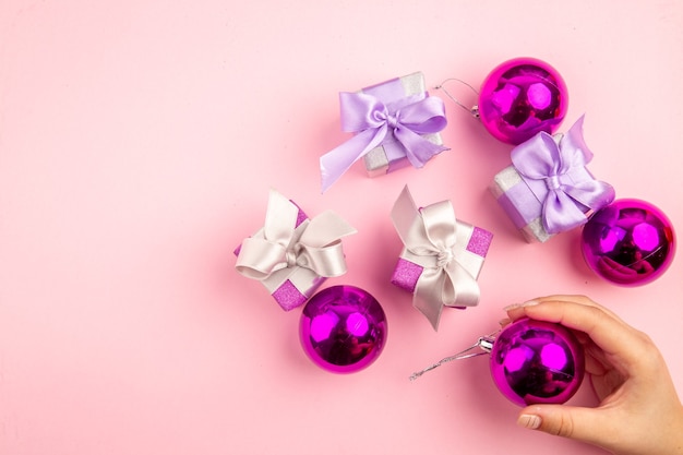 ピンクの表面にクリスマスツリーのおもちゃと小さなプレゼントの上面図