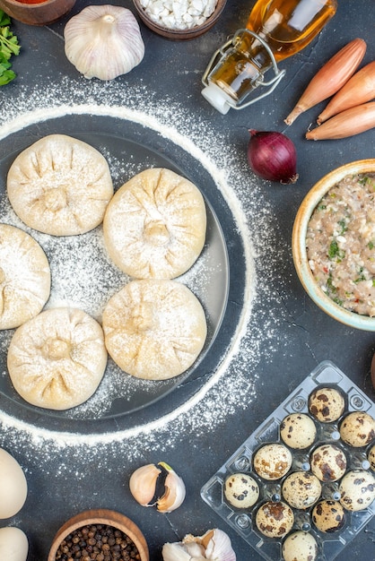 회색 배경 음식 파이 케이크에 다른 재료를 넣은 작은 원시 만두는 맛있는 고기 반죽 색 밀가루를 굽는다