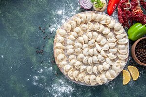 top view little raw dumplings with flour and vegetables on a dark background meat dough food dish calorie color vegetable meal
