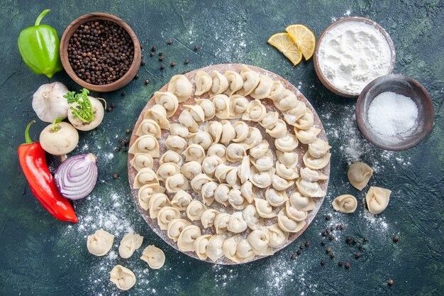 Top view little raw dumplings with flour on dark gray background dough color food food dish meat calorie meal