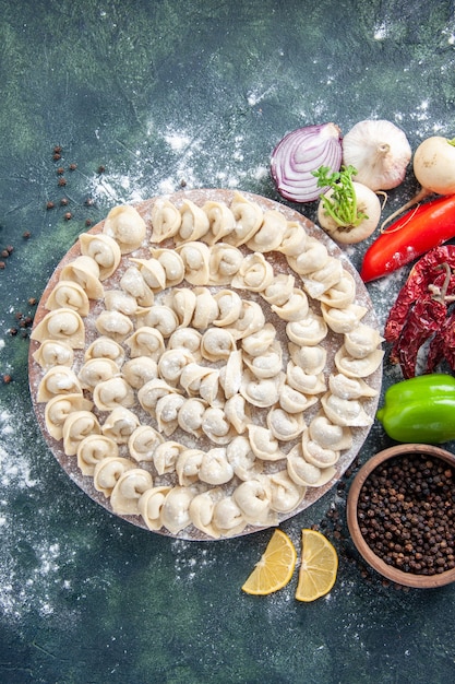 Top view little raw dumplings with flour and vegetables on dark background meat dough food dish calorie color vegetable meal